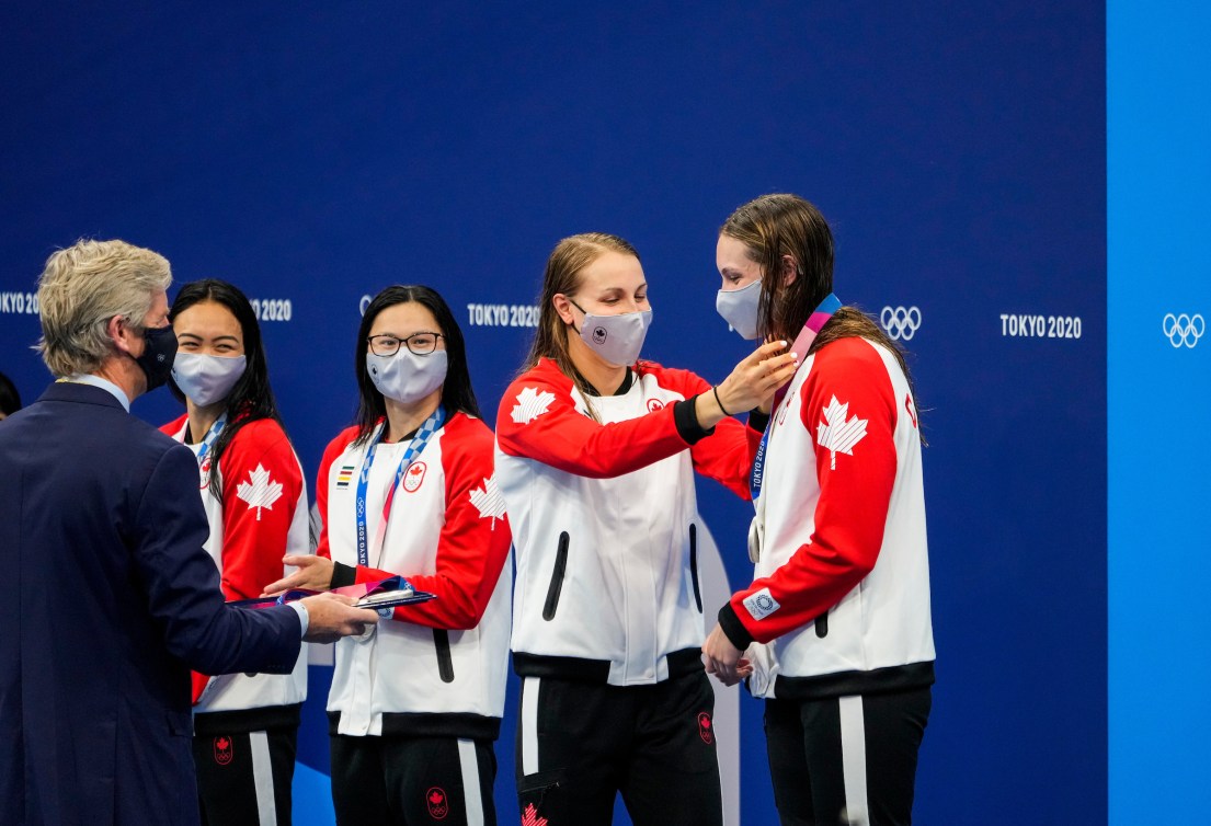 Rebecca Smith puts medal on Penny Oleksiak 