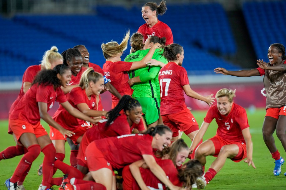 Team Canada celebrates on the field following the win