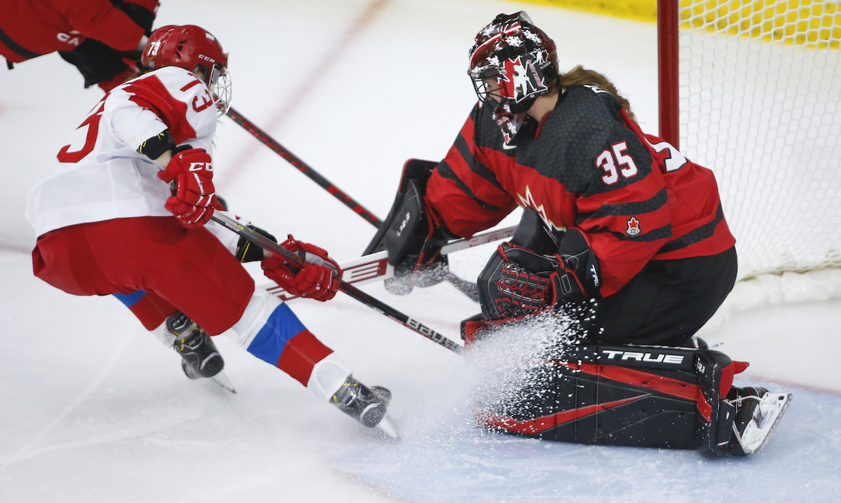 Russia's Viktoria Kulishova, left, has her shot blocked by Canada's goalie Ann-Renee Desbiens during second period IIHF Women's World Championship hockey action in Calgary, Alta., Sunday, Aug. 22, 2021. THE CANADIAN PRESS/Jeff McIntosh