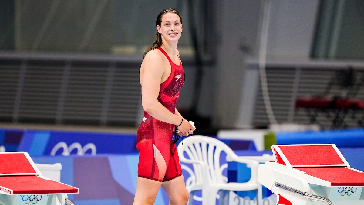 Penny Oleksiak standing on the pool deck