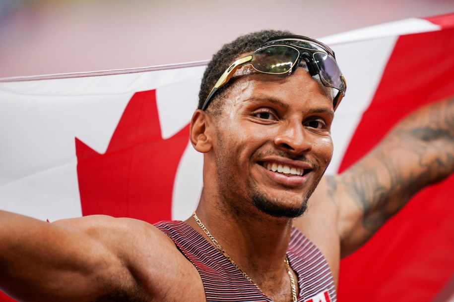 Andre De Grasse smiles with the Canadian flag