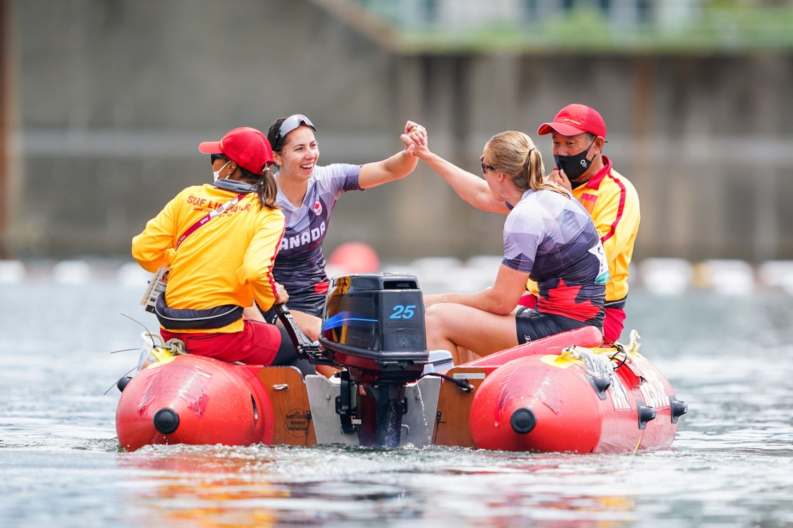 Laurence Vincent Lapointe and Katie Vincent hold hands on a rescue boat after falling in the water in celebration 