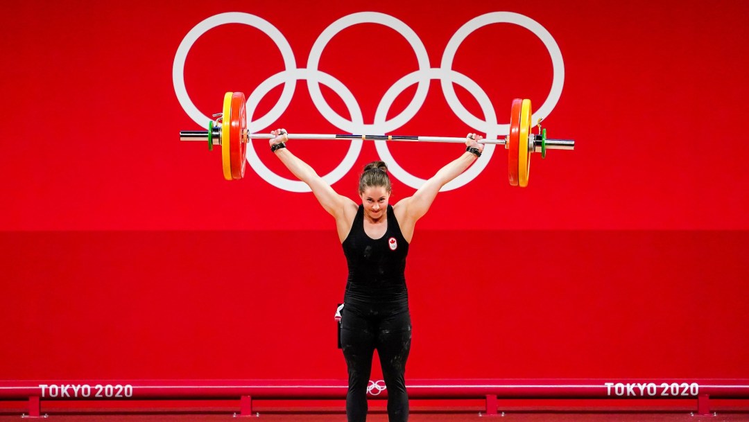 Maude Charron with the bar bell lifted above her head