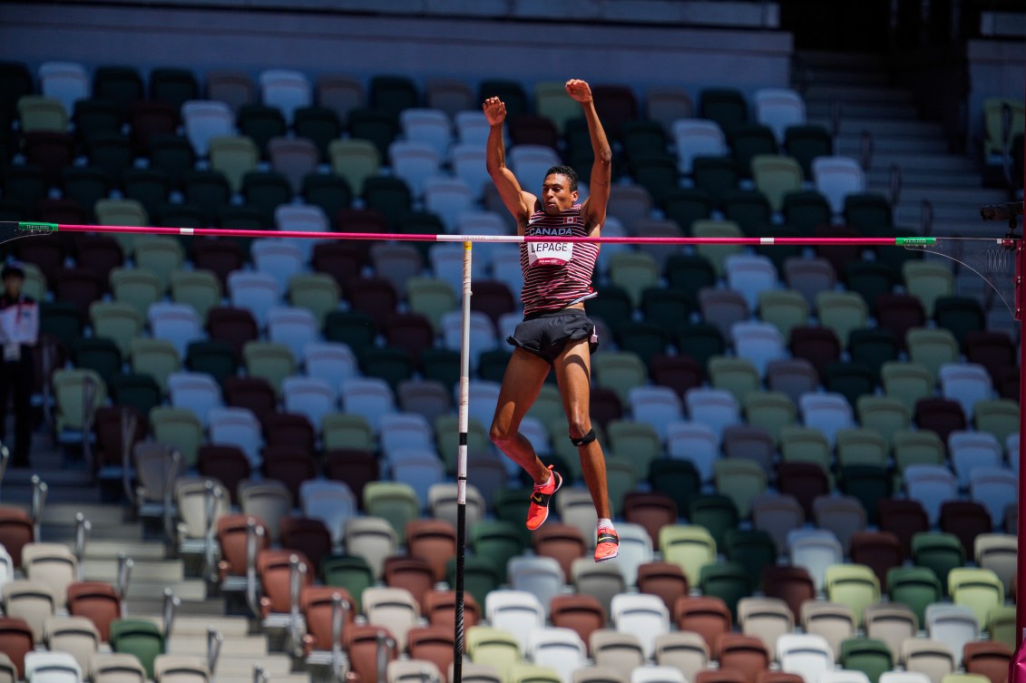 Pierce LePage falls to the padding after a successful pole vault 