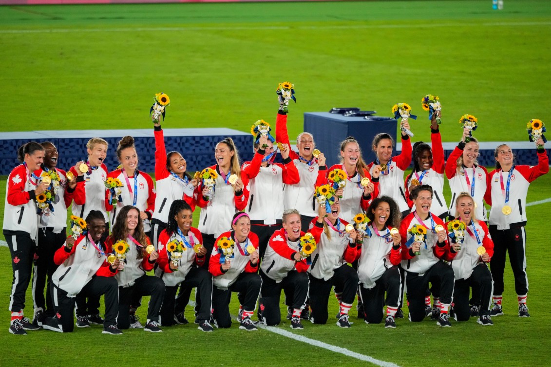 Women's soccer team pose with medals after victory ceremony 