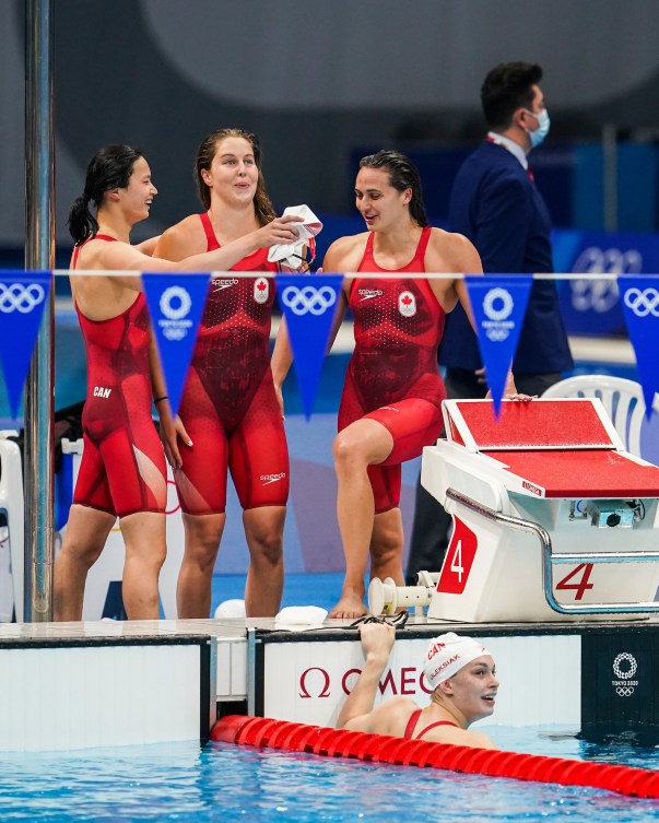 Canadian medley relay team celebrates on pool deck 