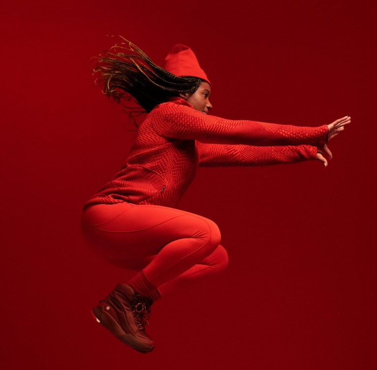 Dawn Richardson Wilson jumps in the air while wearing red pants and red top