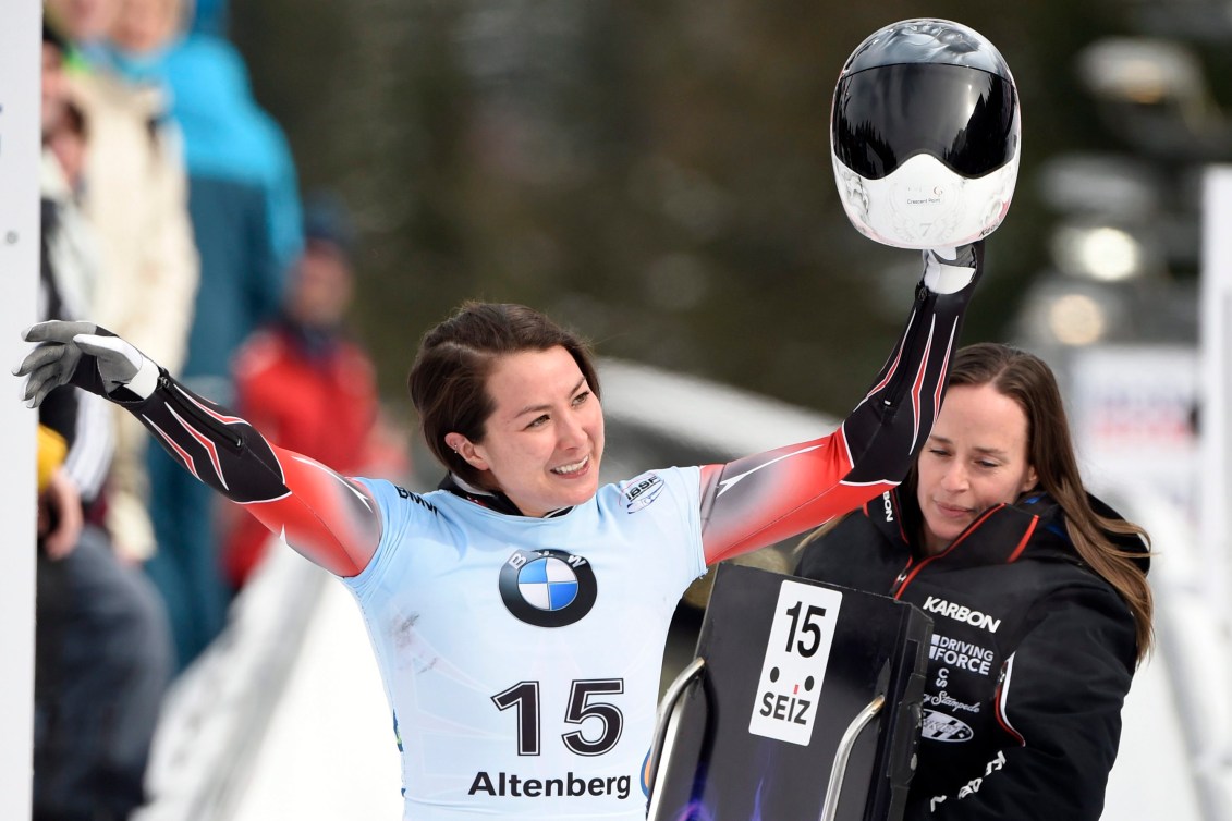 Jane Channell waves her helmet in the air as she walks the track at the end of a run 