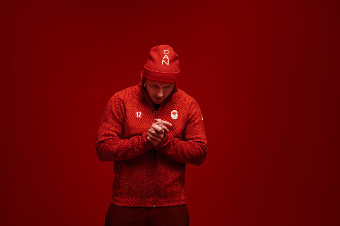 Justin Kripps rubs his hands together while wearing red sweater and toque
