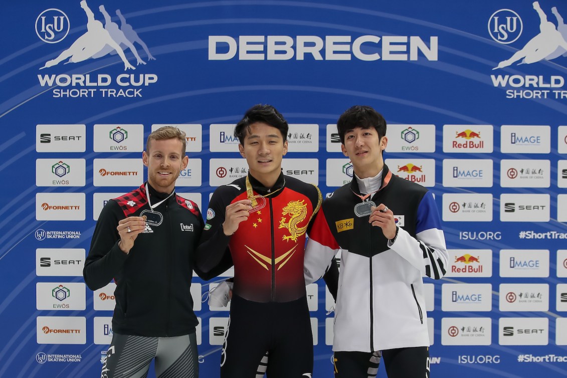 DEBRECEN, HUNGARY - NOVEMBER 20: Ziwei Ren of China, Pascal Dion of Canadaand Jang Hyuk Park of South Korea pose on podium after Men`s 1500m final race during the ISU World Cup Short Track at Fönix hall on November 20, 2021 in Debrecen, Hungary. (Photo by Christian Kaspar-Bartke - International Skating Union/International Skating Union via Getty Images)