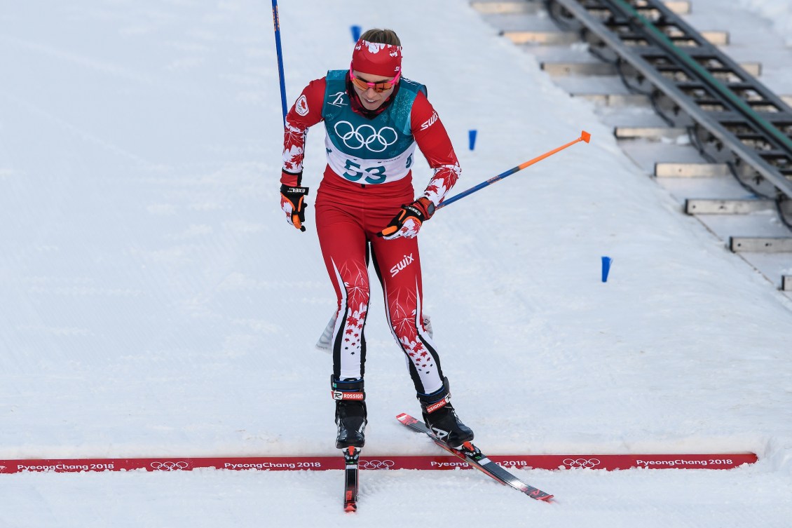 Cross country skier crosses finish line in a race