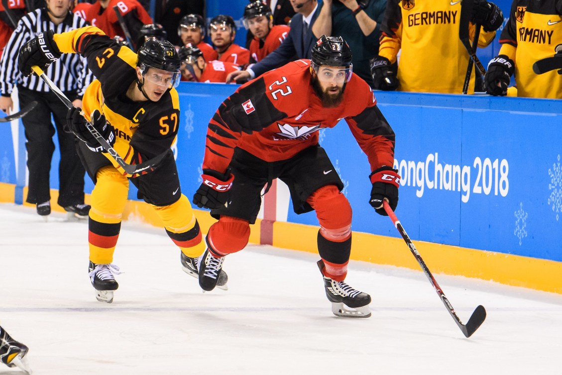 Eric O'Dell skates hard for the puck past a German player