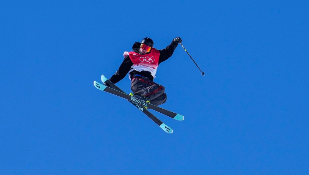 Max Moffatt grabs his ski while performing a mid air trick