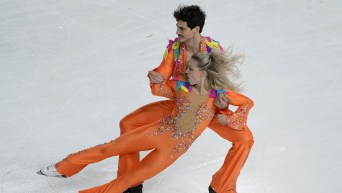 Piper Gilles and Paul Poirier perform a slide move in their ice dance program