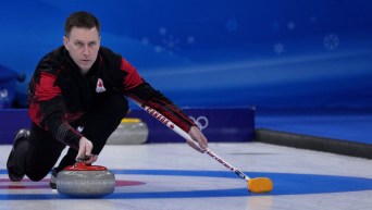 Brad Gushue throws a stone from the hack