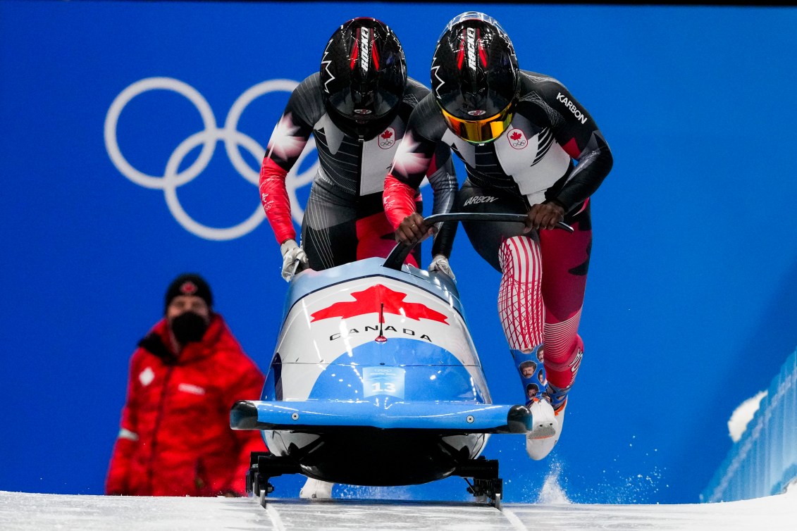 Cynthia Appiah and Dawn Richardson Wilson , of Canada, start the women's bobsleigh heat 3 at the 2022 Winter Olympics, Saturday, Feb. 19, 2022, in the Yanqing district of Beijing. (AP Photo/Dmitri Lovetsky)