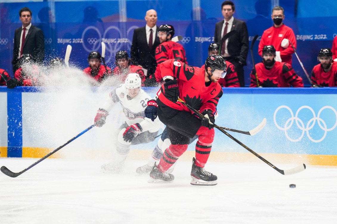 Eric Staal #12 of Team Canada plays the puck against Brian Cooper #23 of Team United States