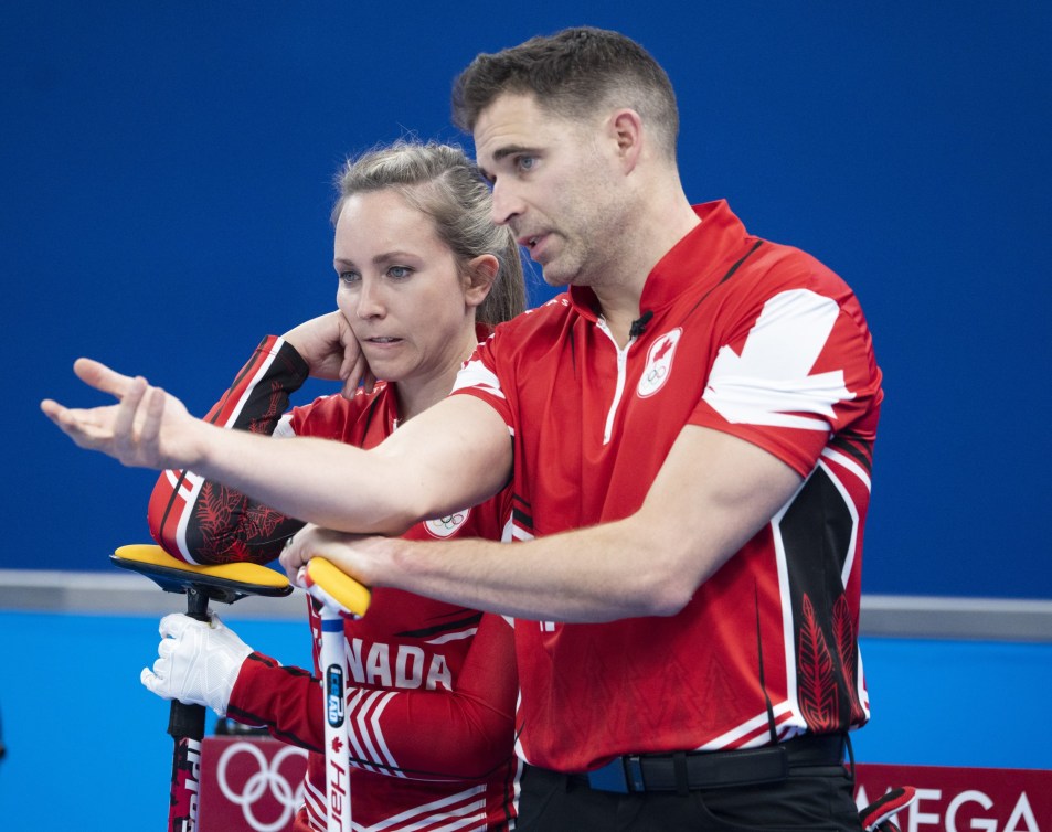 Rachel Homan and John Morris discuss a shot 