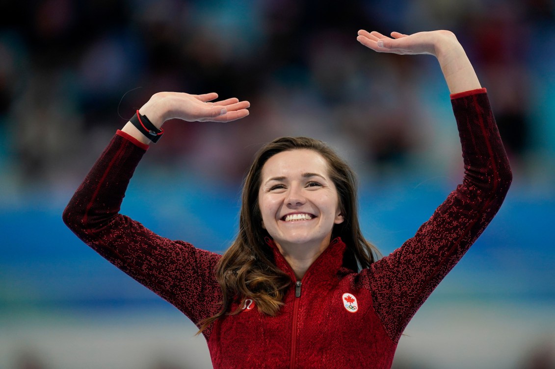 Isabelle Weidemann raises her hands on the podium in celebration