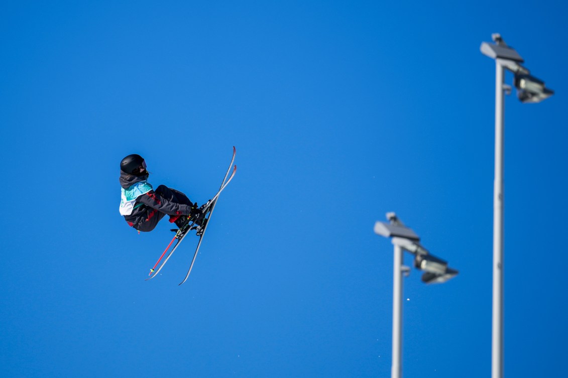 Megan Oldham grabs her ski during a big air trick