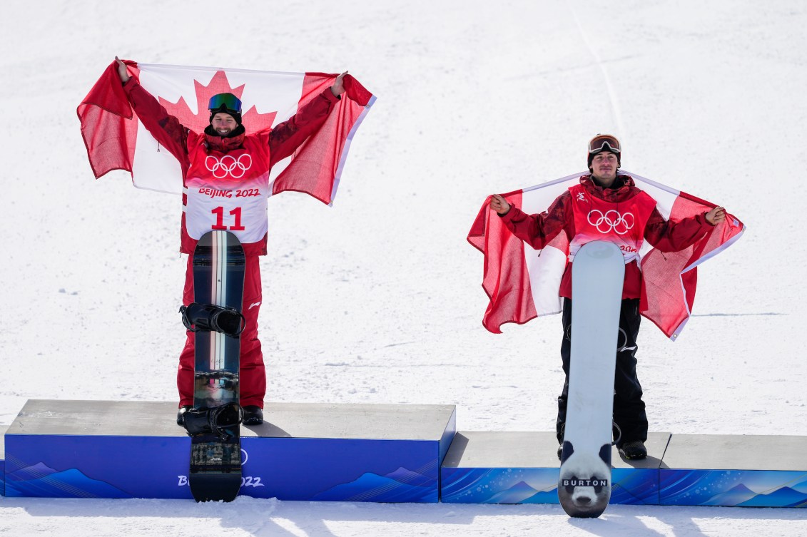 Max Parrot and Mark McMorris hold Canadian flags on the podium