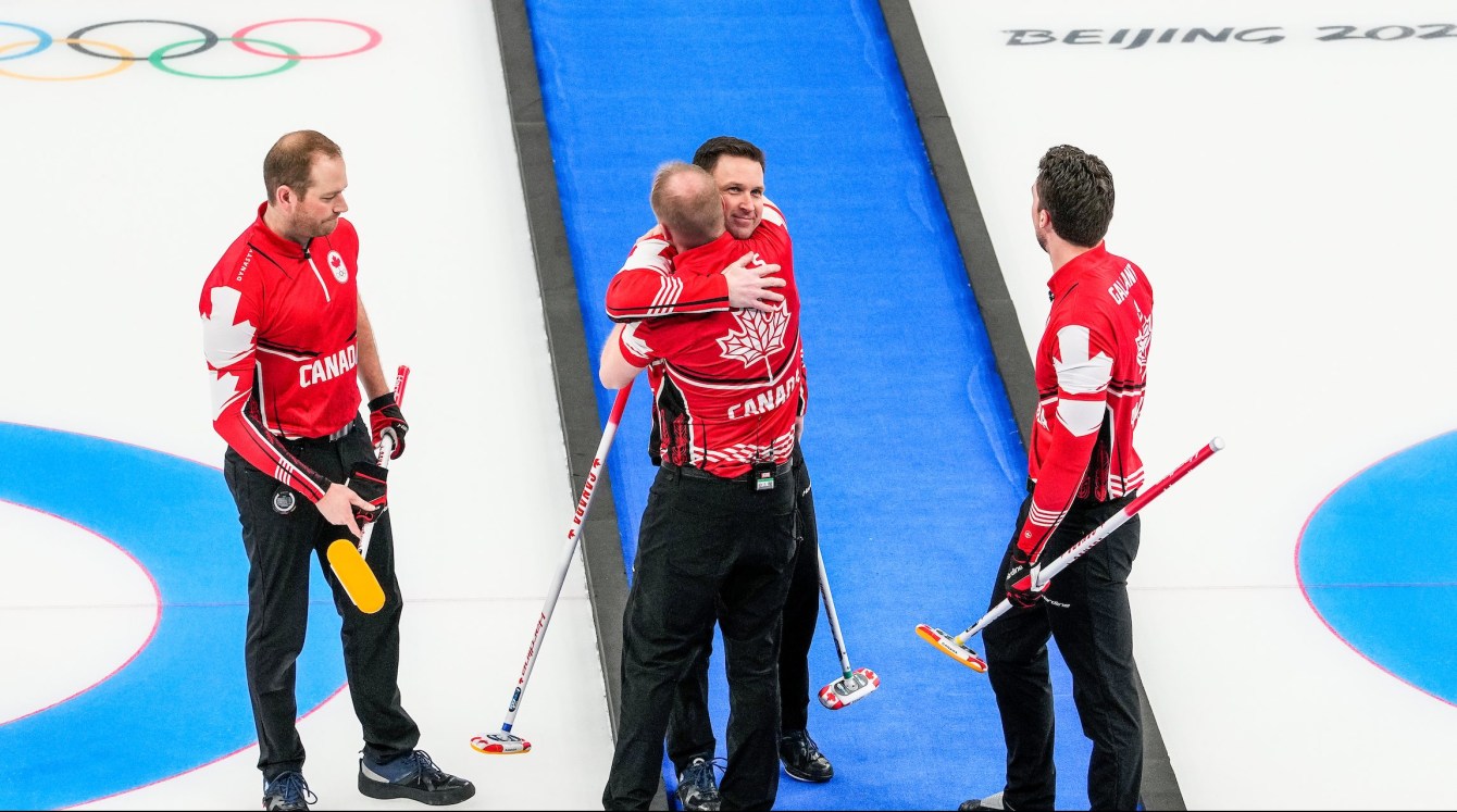 Brad Gushue and Mark Nichols hug