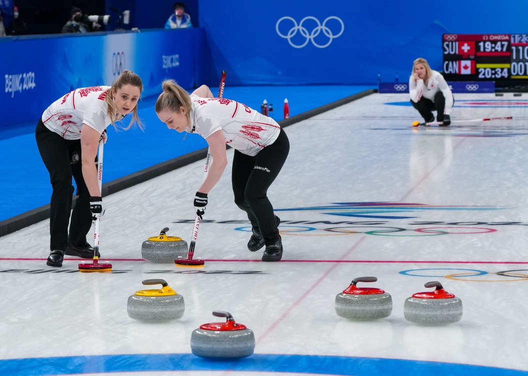 Jennifer Jones watches her shot being swept by Jocelyn Peterman and Dawn McEwen