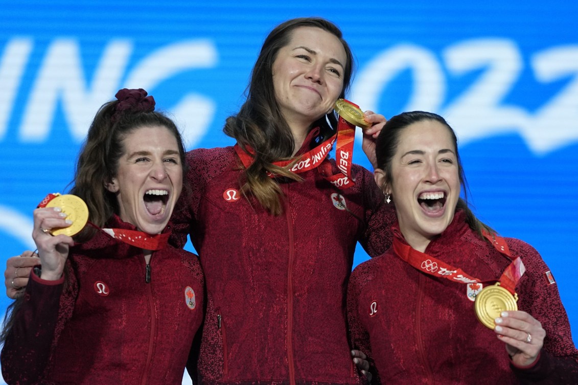 Isabelle Weidemann, Ivanie Blondin, Valerie Maltais laugh while wearing their gold medals
