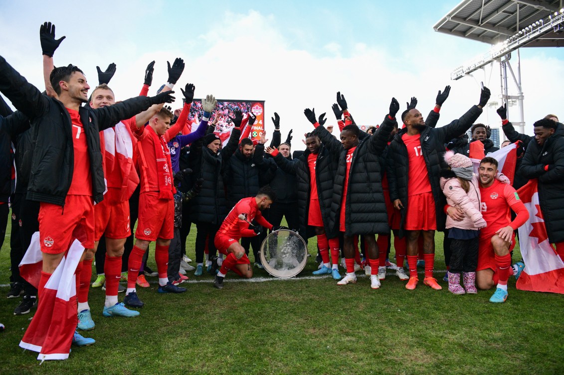 Jonathan Osorio bangs a drum as his teammates do a viking clap 