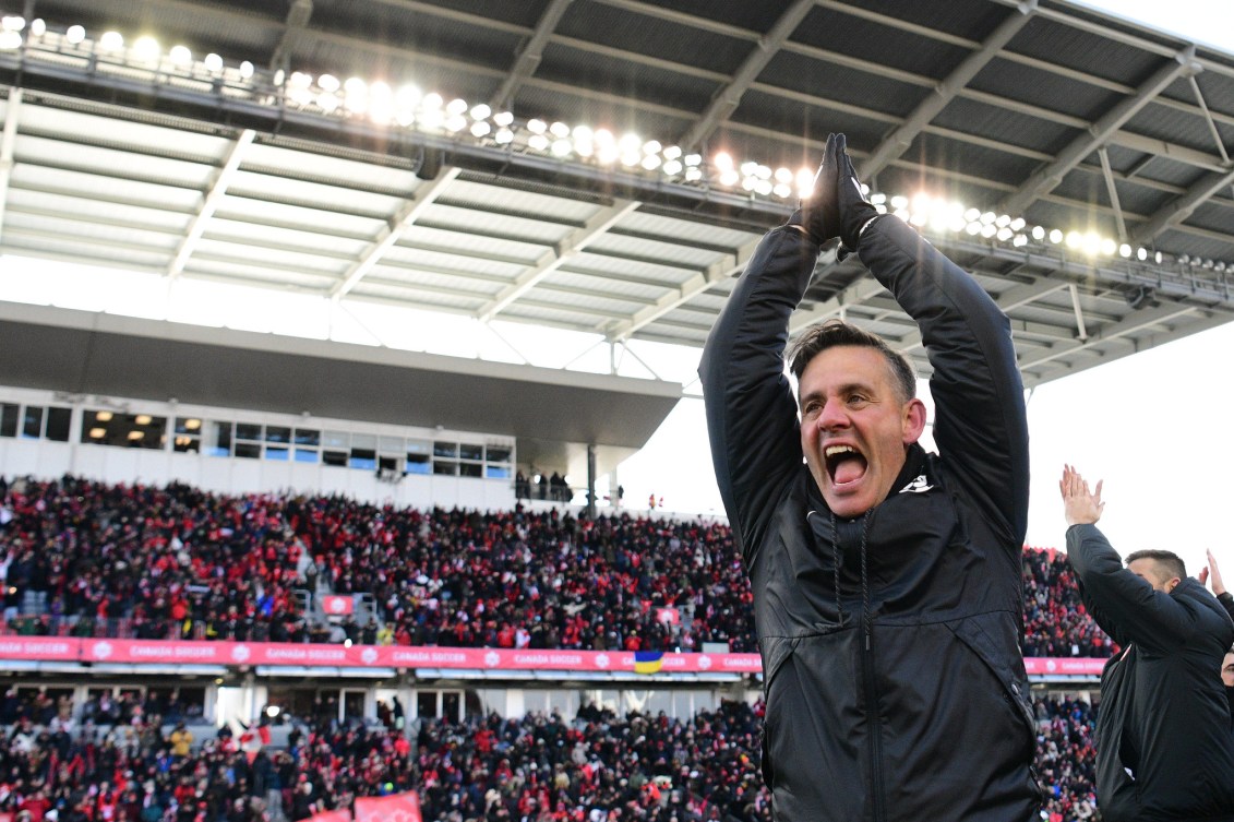 John Herdman claps his hands above his head 