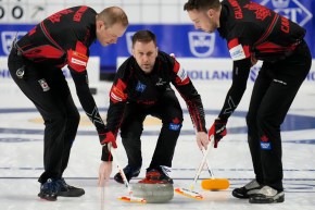 Brad Gushue throws a stone at the world championships