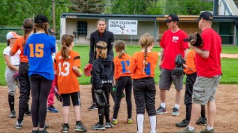 Softball pitcher Lauren Regula talks to young players during an on field clinic