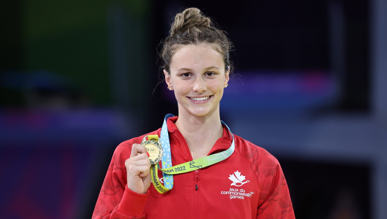 Summer McIntosh holds her gold medal on the podium