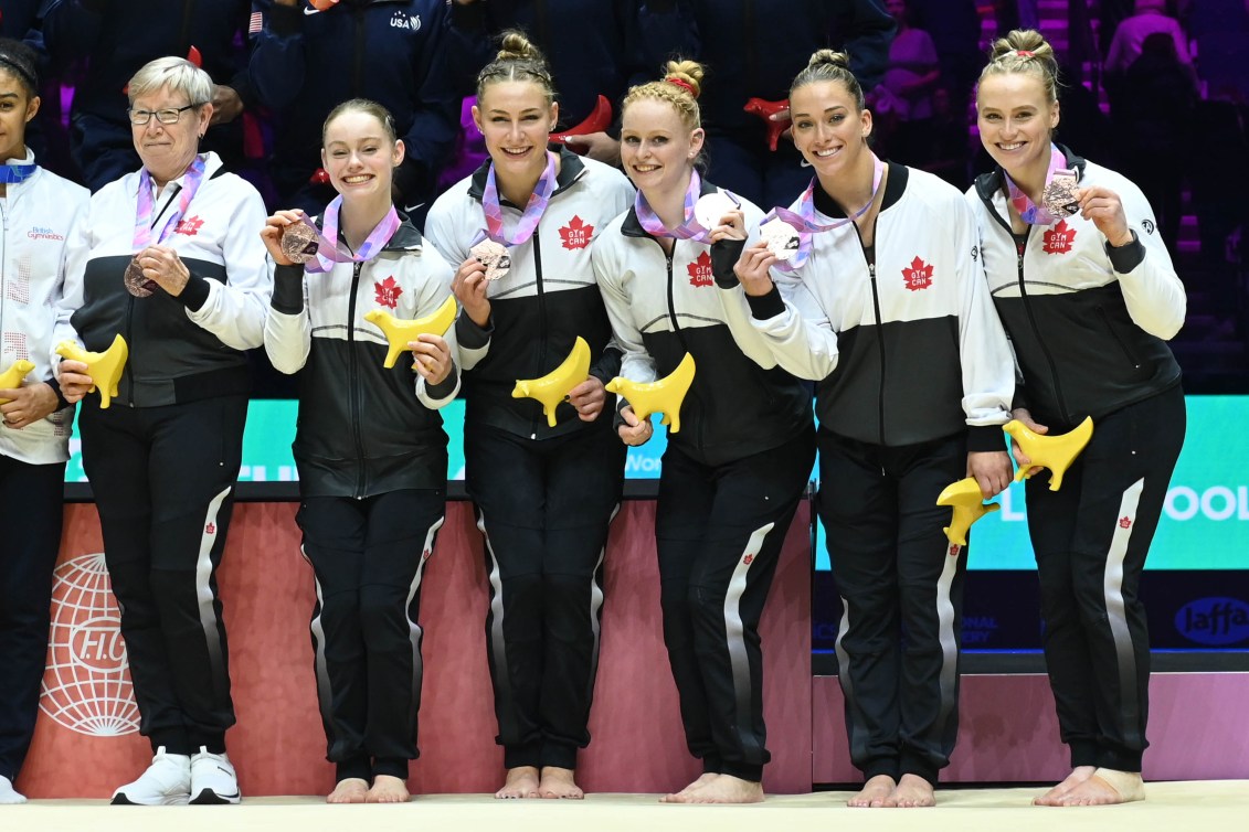 Team Canada gymnasts smile with their bronze medals 