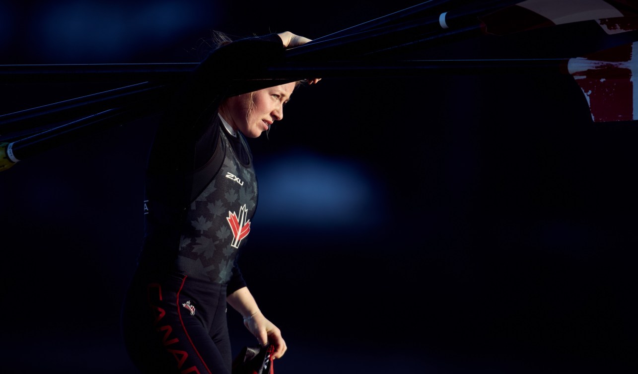 Caileigh Filmer carries rowing oars on her shoulder