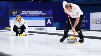 Jennifer Jones yells as Brent Laing sweeps a stone down the ice