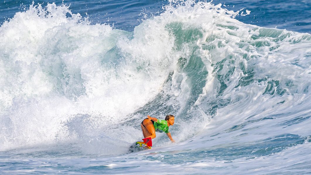 Erin Brooks rides a big wave on a surfboard