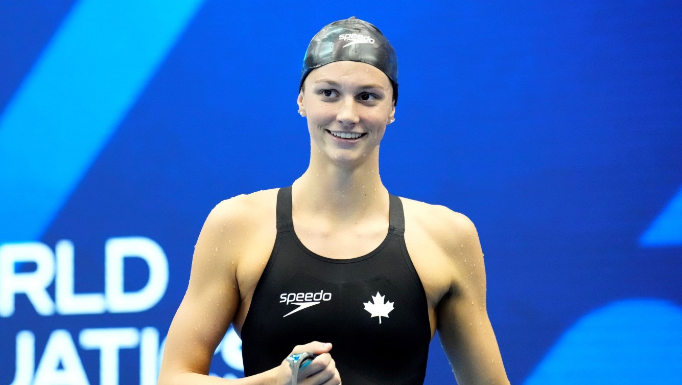 Summer McIntosh smiles on the pool desk after winning a race