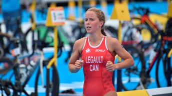 Emy Legault runs in a red swimsuit past a row of bikes