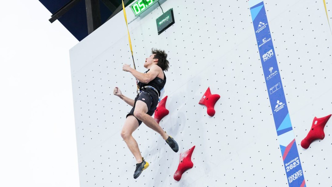 A speed climber screams in happiness after reaching the top of the wall