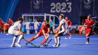 A group of field hockey players fight for the ball