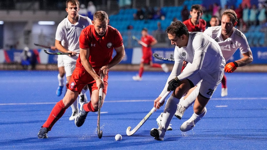 A group of field hockey players fight for the ball