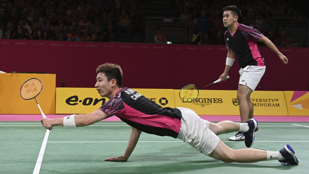 Adam Dong dives on the badminton court.