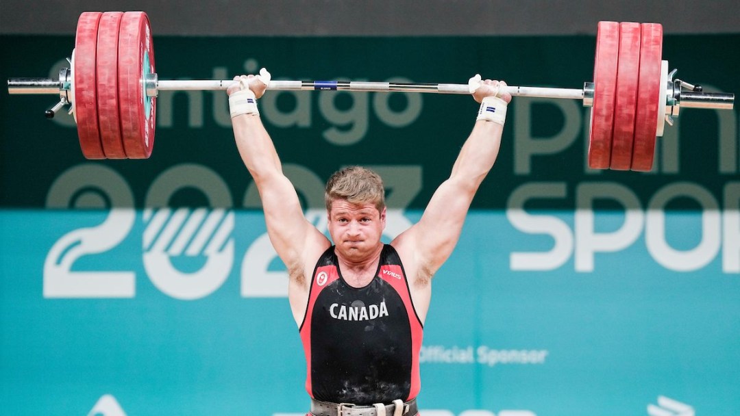 Athlete lifts a barbell over his head