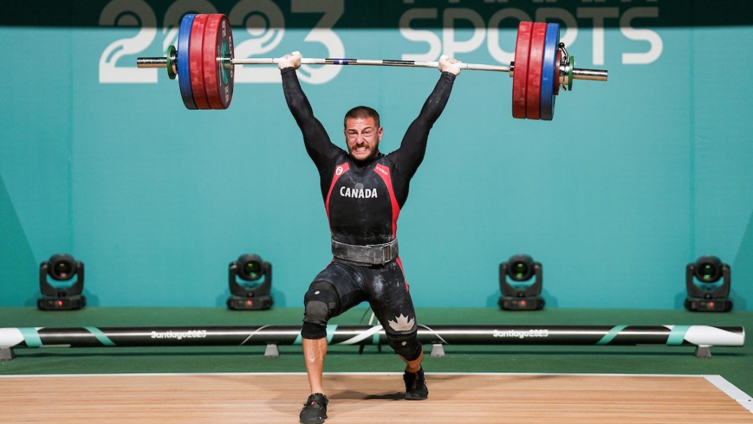 Weightlifter hoists barbell above his head
