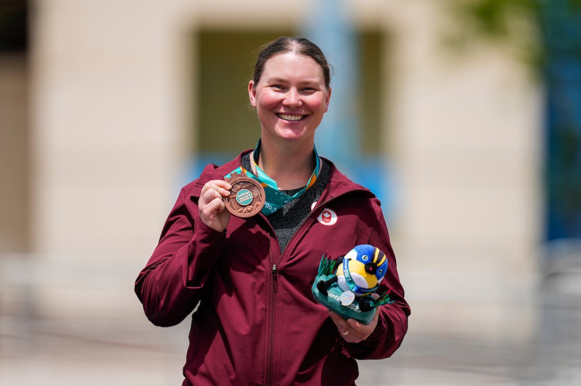 Shannon Westlake poses with her bronze medal. The background of the photo is blurred.