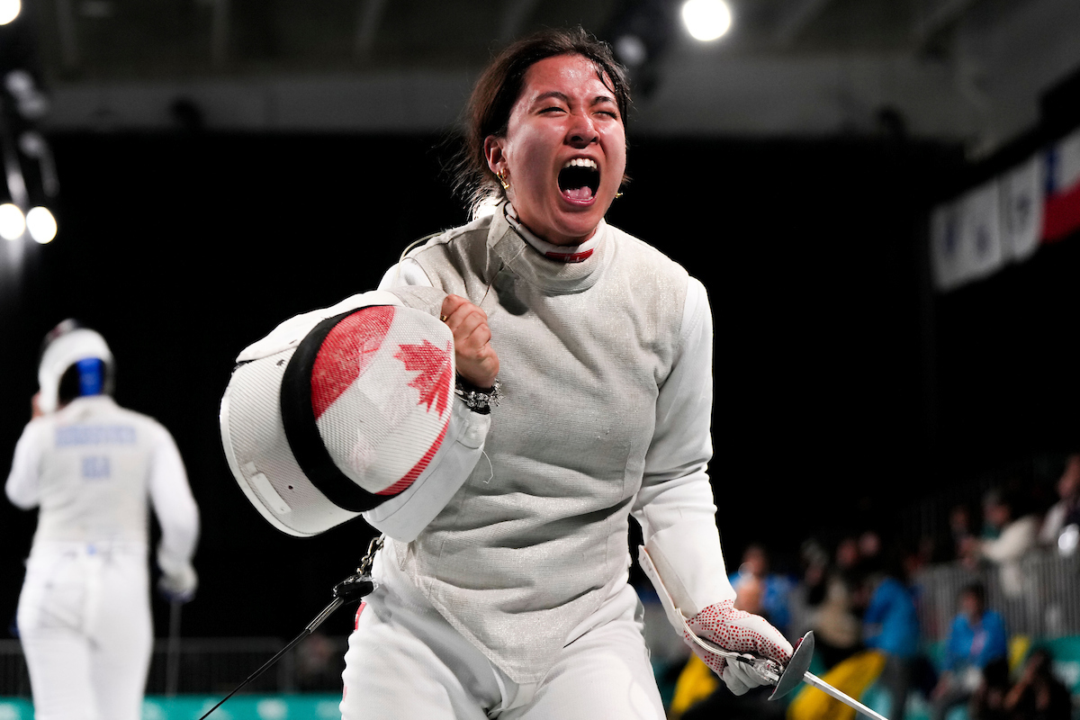 Jessica Guo screams with her fencing mask off after a win