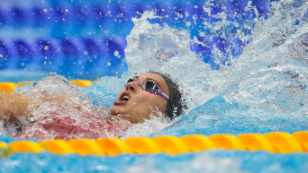 Canada's Kylie Masse swims the back stroke in a pool.