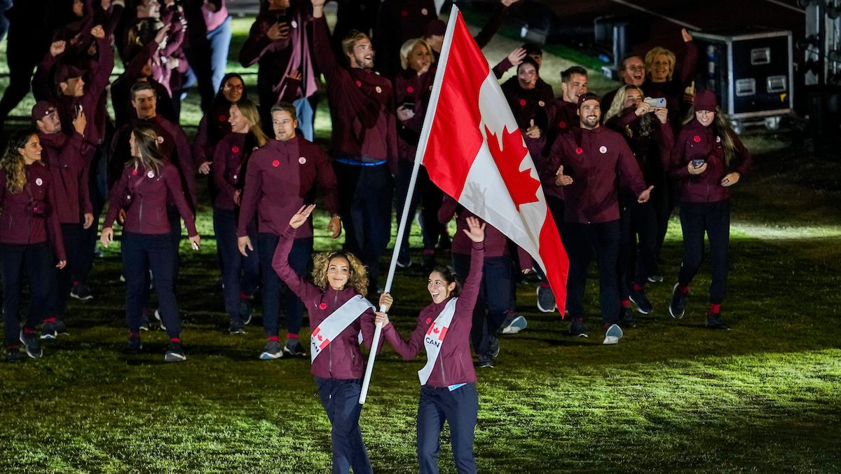 Brandie Wilkerson and Melissa Humana-Paredes carry the Canadian flag in front of their teammates at the 2023 Pan Am Games in Santiago
