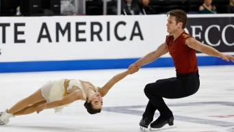 Figure skaters from Canada hold hands and spin around